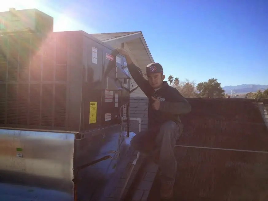 HVAC technician performing Heat Pump Repair on a rooftop unit in Bowling Green