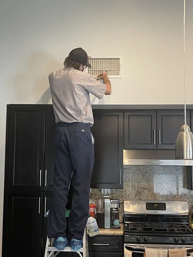 Technician inspecting an air vent during HVAC service in Bowling Green